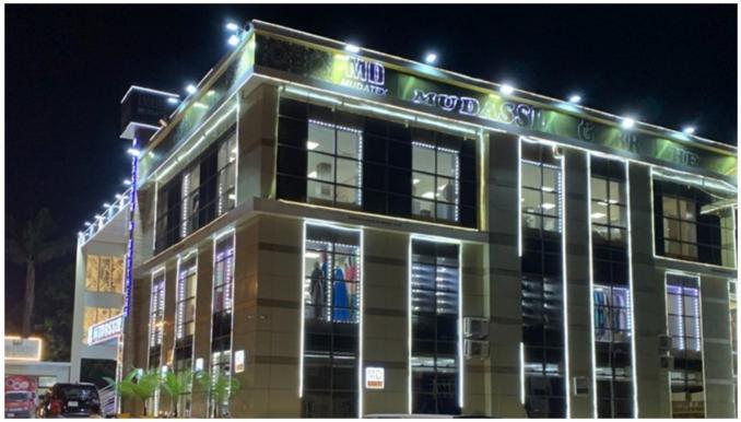 Mudatex outlet exterior illuminated at night